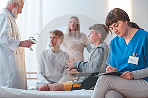 Hospital room with helpful doctors and ill patient