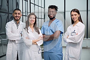 Hospital staff with and clipboard looking at camera in clinic