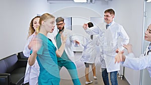 Hospital stuff of nurses and doctors dancing excited in front of the camera they feeling very happy and smiling large