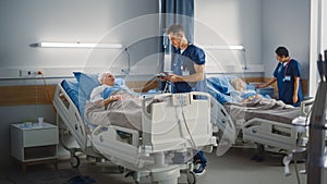 Hospital Ward: Friendly Male Nurse Talks Reassuringly to Elderly Patient Resting in Bed. Doctor Us