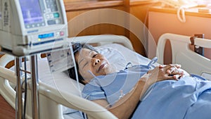 Hospitalized elderly patient senior woman sleeping on bed in hospital ward room with iv medical infusion pump