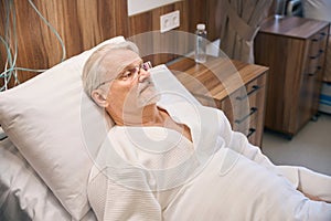 Hospitalized mature man lying in medical ward