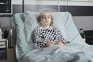 Hospitalized sick little girl resting in children healthcare clinic