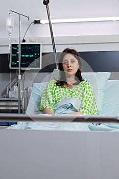 Hospitalized sick woman with nasal oxygen tube looking into camera