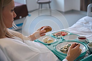 Hospitalized woman having lunch in inpatient facility ward