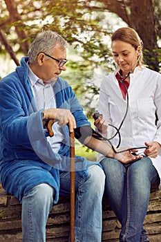 Hospitals, Labs and Clinics- assessment of blood pressure elderly man.