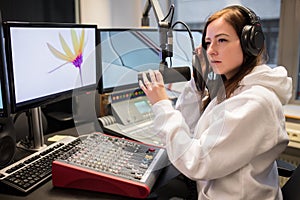 Host Adjusting Headphones And Microphone At Table In Radio Studi