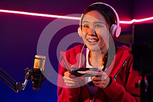 Host channel smiling Asian with joystick playing online game. Stratagem.