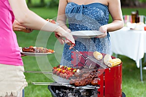 Host serving meals on barbecue party