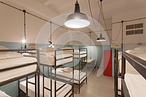 Hostel bedroom interior. Clean beds and bright light lamps