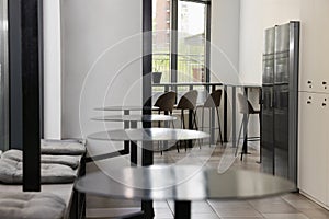 Hostel dining room interior with modern furniture and refrigerators