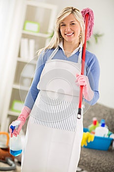 Hostess with equipment for cleaning house posing