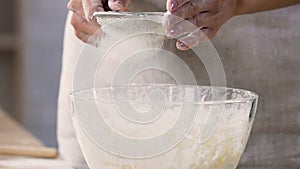 Hostess sifting extra class flour through sieve preparing tasty aromatic pies