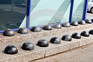 Hostile design steel half ball mounted on the edge of the curb prevents the homeless sitting