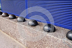 Hostile design steel half ball mounted front of building on the edge of the curb street