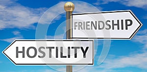 Hostility and friendship as different choices in life - pictured as words Hostility, friendship on road signs pointing at opposite