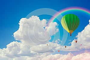 Hot air ballloons and rainbow with cloudy blue sky background