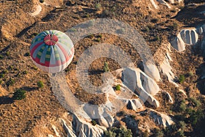 Hot air balloon with blue and red colors pattern rising over the Cappadocian valley