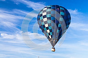 Hot air balloon with a burning burner scorched the envelope against the blue sky