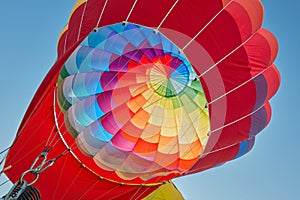 Hot air balloon, colorful aerostat inflating, blue sky