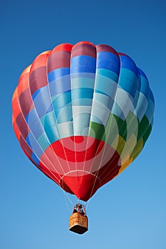 Hot air balloon, colorful aerostat with people, blue sky