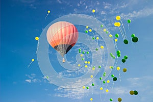 Hot-air balloon with colorful balloons in the blue sky