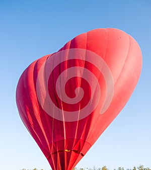 Hot air balloon floating in the sky big red hot air balloon in the shape of a big heart for love and world peace