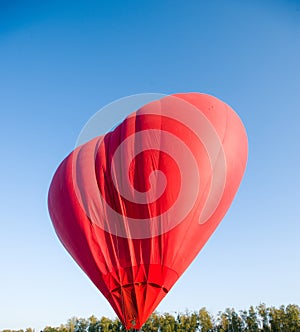 Hot air balloon floating in the sky big red hot air balloon in the shape of a big heart for love and world peace