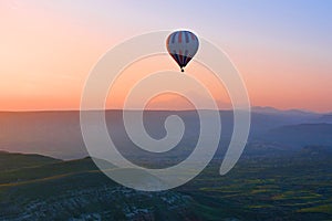Hot air balloon flying over amazing landscape at sunrise, Cappad
