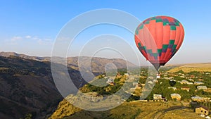 Hot air balloon flying over beautiful Armenian Halidzor village and mountains