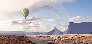 Hot Air Balloon flying over Desert Rocky Mountain American Landscape.