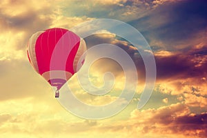 Hot Air Balloon Flying over Dramatic Sunset Sky