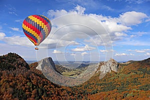 Hot air balloon flying over old volcano. Auvergne, France
