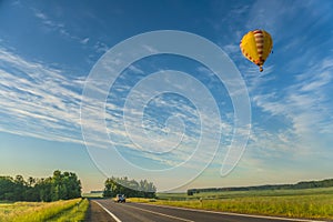 Hot air balloon flying over the road