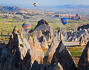 Hot air balloon flying over rock landscape at Cappadocia, Turkey