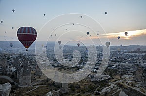 Hot air balloon flying over rocks and valley landscape at Cappadocia near Goreme Turkey