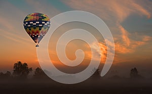 Hot air balloon flying at yellow sunrise