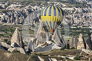 A hot air balloon navigates past fairy chimneys near goreme in Turkey.