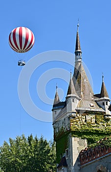 Hot air balloon next to a castle tower in Budapest city
