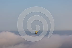 Hot air balloon on over the clouds before sunset time