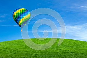 Hot air balloon over green field