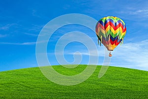 Hot air balloon over green field