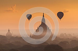 Hot air balloon over plain of Bagan in misty morning, Myanmar