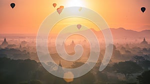 Hot air balloon over plain and pagoda of Bagan in misty morning