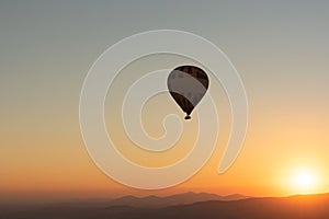 Hot air balloon in the sky during sunrise. Travel, dreams come true concept. Flying over the valley in Goreme