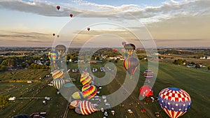 hot air balloons in the air during sunset in a field