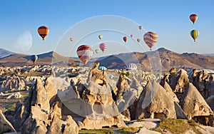 Hot air balloons fly in clear morning sky near Goreme, Kapadokya, Turkey photo