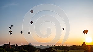 Hot air balloons flying over beautiful pagodas at sunrise in Bagan, Myanmar