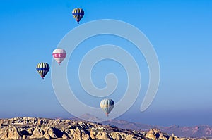 Hot air balloons flying over the lunar landscape of Goreme in Cappadocia, Turkey