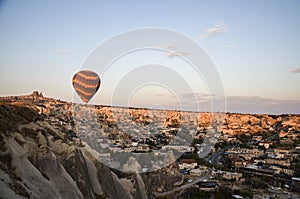 Hot air balloons flying over the valley and rock formations with fairy chimneys near Goreme, Cappadocia, Turkey